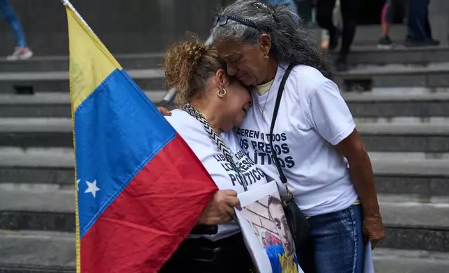 Barbara Bracho, left, mother of Gilberto Bracho, is embraced by Zoraida Gonzalez, mother of Miguel Estrada, both of whom consider their sons to be political prisoners, protest for their releases outside the United Nations office in Caracas, Venezuela, Wednesday Feb. 18, 2026. (AP Photo/Ariana Cubillos)