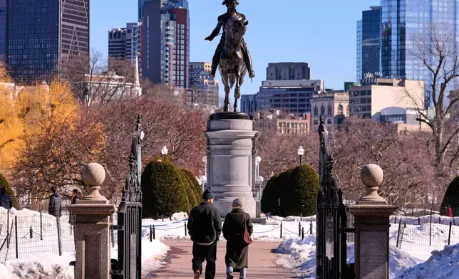 A couple walks toward a statue of George Washington on horseback at the Public Garden, Friday, Feb. 13, 2026, in Boston. (AP Photo/Charles Krupa)