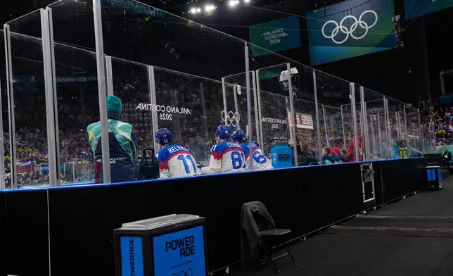 Slovakia's Milos Kelemen, left, Slovakia's Erik Cernak, center, and Slovakia's Patrik Koch sit in the penalty box during a preliminary round match of men's ice hockey between Sweden and Slovakia at the 2026 Winter Olympics, in Milan, Italy, Saturday, Feb. 14, 2026. (AP Photo/Petr David Josek)