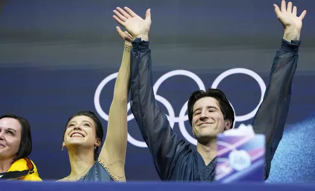 Anastasiia Golubeva and Hektor Giotopoulos Moore of Australia wait for scores after competing, during the pairs figure skating short program at the 2026 Winter Olympics, in Milan, Italy, Sunday, Feb. 15, 2026. (AP Photo/Natacha Pisarenko)