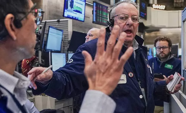 Options trader Phil Fracassini, center, works on the floor of the New York Stock Exchange, Monday, Feb. 2, 2026. (AP Photo/Richard Drew)