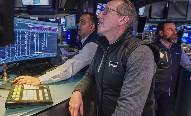 Specialists, from left, Dilip Patel, Glenn Carell, and Michael Pistillo work on the floor of the New York Stock Exchange, Monday, Feb. 2, 2026. (AP Photo/Richard Drew)