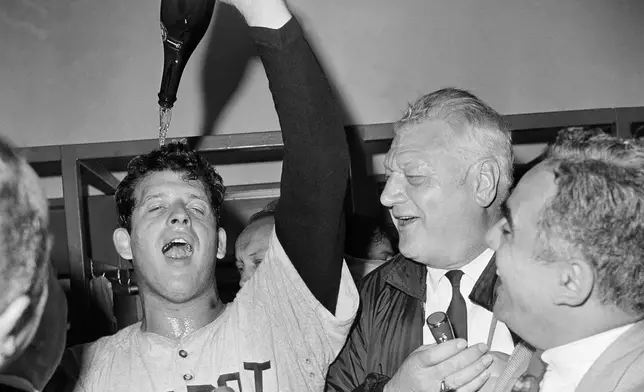 FILE- In this Oct. 10, 1968, file photo, Detroit Tigers Pitcher Mickey Lolich he pours bottle of champagne on his head in clubhouse after defeating the St. Louis Cardinals 4-1 in Game 7 of baseball's World Series in 1968. (AP Photo/File)