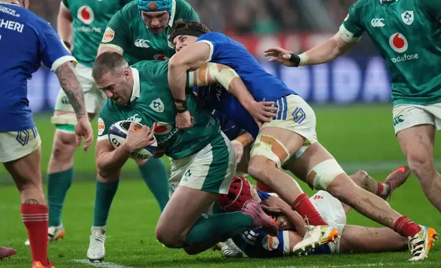 Ireland's Stuart McCloskey, centre right, and France's Oscar Jegou, centre, challenge for the ball during the Six Nations rugby match between France and Ireland in Paris, Thursday, Feb. 5, 2026. (AP Photo/Thibault Camus)