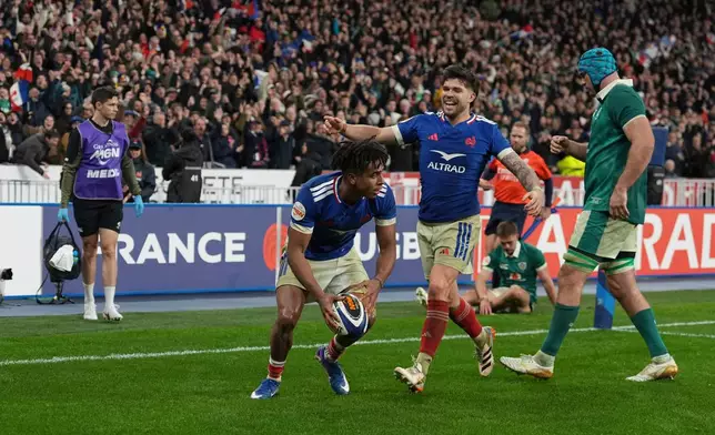 France's Theo Attissogbe, centre left, celebrates after scoring a try with Matthieu Jalibert during the Six Nations rugby match between France and Ireland in Paris, Thursday, Feb. 5, 2026. (AP Photo/Thibault Camus)
