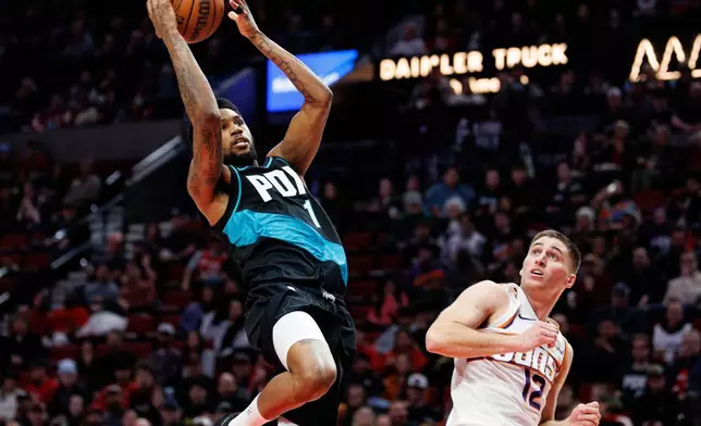 Portland Trail Blazers guard Blake Wesley, left, drives to the basket against Phoenix Suns guard Collin Gillespie, right, during the second half of an NBA basketball game Tuesday, Feb. 3, 2026, in Portland, Ore. (AP Photo/Howard Lao)