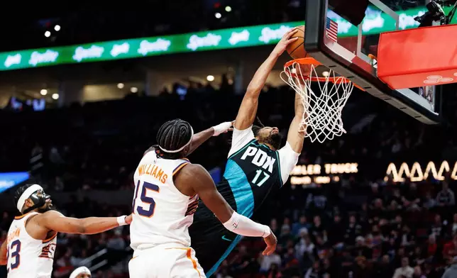 Portland Trail Blazers guard Shaedon Sharpe, right, dunks the ball against the Phoenix Suns during the second half of an NBA basketball game Tuesday, Feb. 3, 2026, in Portland, Ore. (AP Photo/Howard Lao)