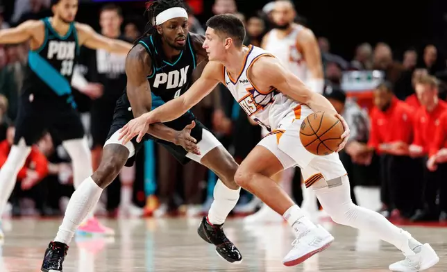 Phoenix Suns guard Grayson Allen, right, dribbles against Portland Trail Blazers forward Jerami Grant, left, during the second half of an NBA basketball game Tuesday, Feb. 3, 2026, in Portland, Ore. (AP Photo/Howard Lao)