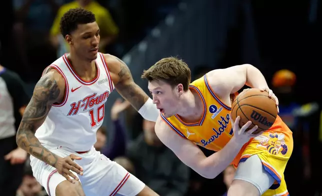 Charlotte Hornets guard Kon Knueppel, right, looks to drive against Houston Rockets forward Jabari Smith Jr. (10) during the first half of an NBA basketball game in Charlotte, N.C., Thursday, Feb. 19, 2026. (AP Photo/Nell Redmond)