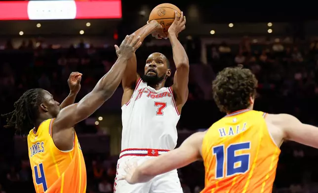 Houston Rockets forward Kevin Durant (7) looks to shoot against Charlotte Hornets guard Sion James (4) and center PJ Hall (16) during the first half of an NBA basketball game in Charlotte, N.C., Thursday, Feb. 19, 2026. (AP Photo/Nell Redmond)