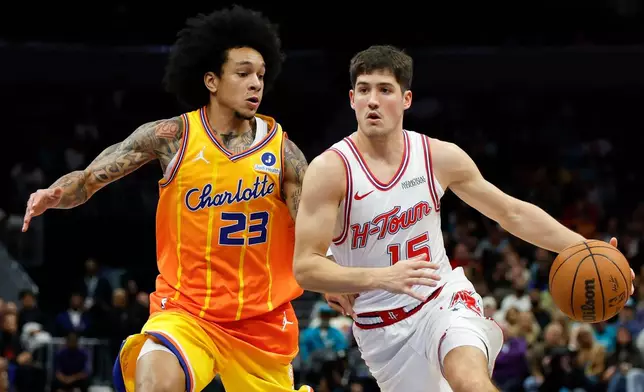 Houston Rockets guard Reed Sheppard, right, drives to the basket against Charlotte Hornets guard Tre Mann (23) during the first half of an NBA basketball game in Charlotte, N.C., Thursday, Feb. 19, 2026. (AP Photo/Nell Redmond)