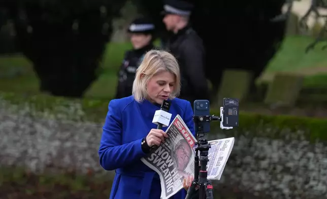 A journalist reports at the entrance gate of the Sandringham Royal Estate in Sandringham, England, Friday, Feb. 20, 2026 after Andrew Mountbatten-Windsor was arrested and held for hours by British police on suspicion of misconduct in public office related to his links to Jeffrey Epstein.(AP Photo/Alastair Grant)