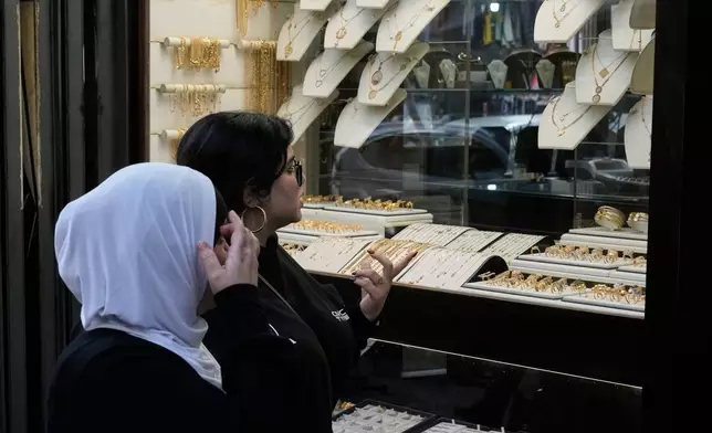 Women look at the storefront of a jewelry shop in Beirut, Lebanon, Monday, Feb. 2, 2026. (AP Photo/Bilal Hussein)
