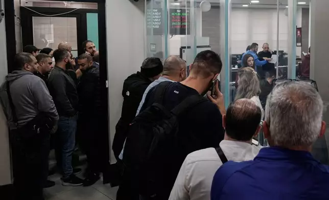 People wait in line to buy gold and silver ounces at a gold and silver trader in the Beirut suburb of Bourj Hammoud, Lebanon, Monday, Feb. 2, 2026. (AP Photo/Bilal Hussein)