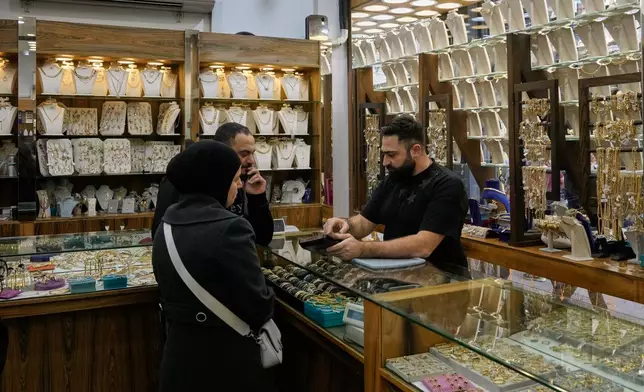 A couple check out pieces of gold at a shop in Beirut, Lebanon, Monday, Feb. 2, 2026. (AP Photo/Bilal Hussein)