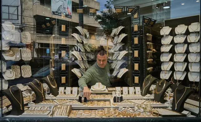 A Lebanese jeweler arranges gold ornaments at his shop's storefront in the Beirut suburb of Bourj Hammoud, Lebanon, Monday, Feb. 2, 2026. (AP Photo/Bilal Hussein)