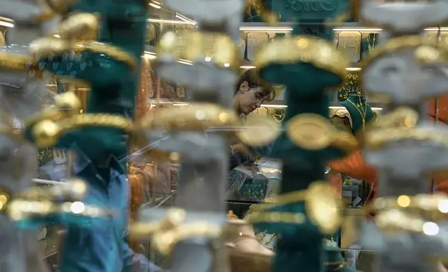 A vendor is seen through the window of a gold shop in Beirut, Lebanon, Monday, Feb. 2, 2026. (AP Photo/Bilal Hussein)