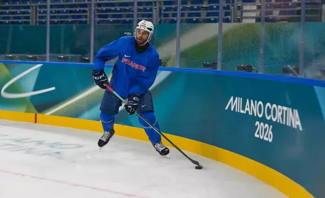 France's Pierre-Edouard Bellemare moves the puck during a training session prior to the 2026 Winter Olympics, in Milan, Italy, Wednesday, Feb. 4, 2026. (AP Photo/Hassan Ammar)