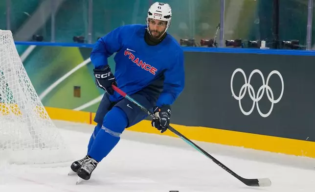 France's Pierre-Edouard Bellemare moves the puck during a training session prior to the 2026 Winter Olympics, in Milan, Italy, Wednesday, Feb. 4, 2026. (AP Photo/Hassan Ammar)