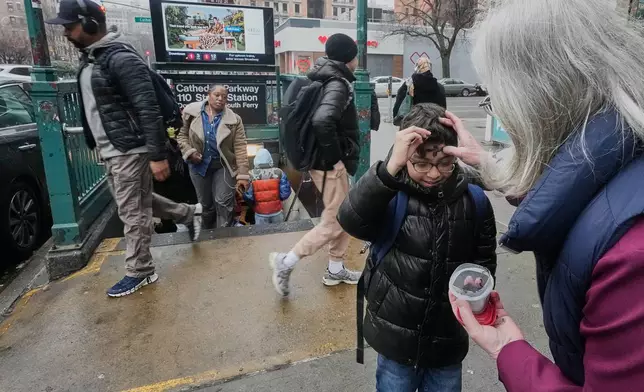 Lorraine Simmons, right, Sacristan of The Cathedral Church of Saint John the Divine, distributes "Ashes To Go" for Ash Wednesday at a subway stop on New York's Upper West Side, Wednesday, Feb. 18, 2026. (AP Photo/Richard Drew)