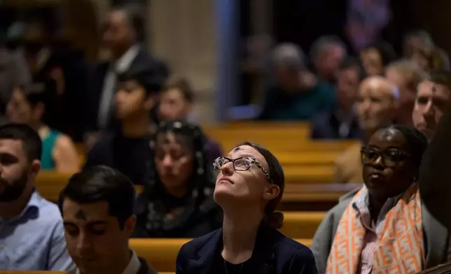 Erica Smeltzer looks up in the pew after receiving ashes during an Ash Wednesday Mass at the Cathedral of St. Matthew the Apostle, Wednesday, Feb., 18, 2026, in Washington. (AP Photo/Rod Lamkey, Jr.)