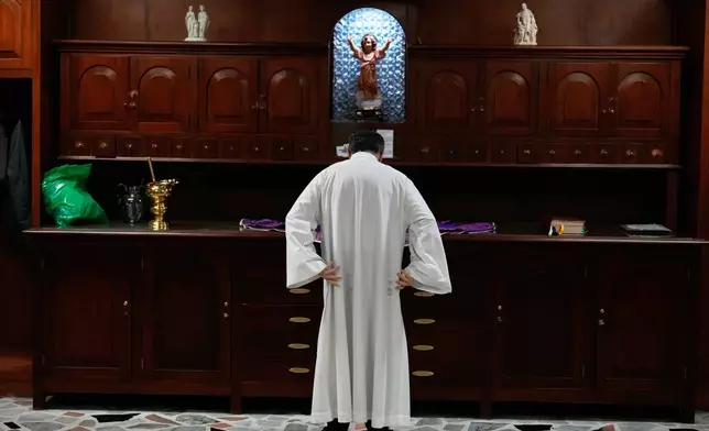 Catholic Priest Oscar Olano gets ready to celebrate Ash Wednesday Mass at the Divine Child Church in Bogota, Colombia, Wednesday, Feb. 18, 2026, the start of the Christian season of Lent, a period of penitence and reflection that leads up to Easter. (AP Photo/Fernando Vergara)