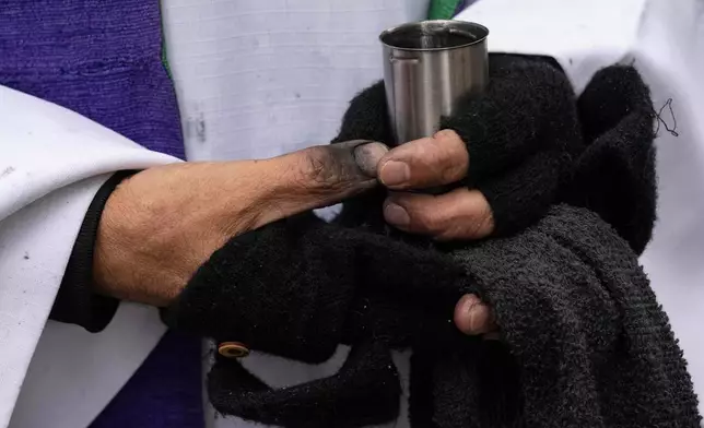 Father Fabian Arias holds a bottle of ash during Ash Wednesday outside the Jacob K. Javits federal building, Wednesday, Feb. 18, 2026, in New York. (AP Photo/Yuki Iwamura)
