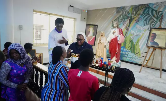 Catholic faithfuls takes holy communion during Ash Wednesday Mass at the church of the Assumption Falomo in Lagos, Nigeria, Wednesday, Feb. 18, 2026. (AP Photo/Sunday Alamba)