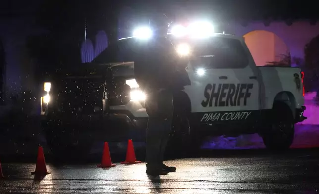 Pima County Sheriff block a road near Nancy Guthrie's home in Tucson, Ariz. on Friday, Feb. 13, 2026. (AP Photo/Ty ONeil)