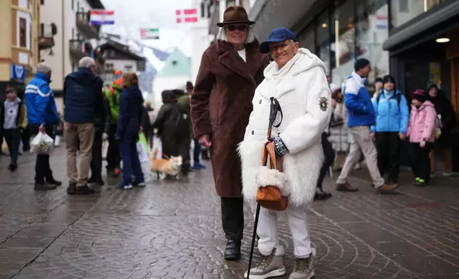 Marina Bozzoli, 82, and Orietta Guarini, 83, pose for a photo in Cortina d'Ampezzo, Italy, Saturday, Feb. 14, 2026. (AP Photo/Alessandra Tarantino)