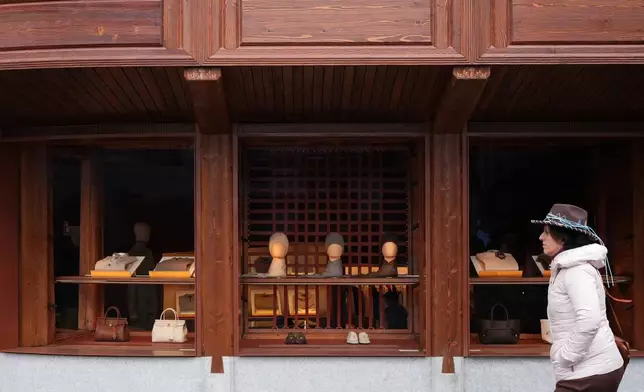 A woman walks past Loro Piana luxury shop in Cortina d'Ampezzo, Italy, Saturday, Feb. 14, 2026. (AP Photo/Alessandra Tarantino)