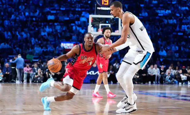 USA Stars guard Tyrese Maxey, left, is defended by World center Victor Wembanyama, of France, during the NBA All-Star basketball game Sunday, Feb. 15, 2026, in Inglewood, Calif. (AP Photo/Mark J. Terrill)
