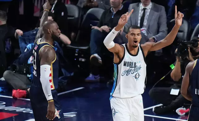 World center Victor Wembanyama, of France, reacts next to USA Stripes forward LeBron James (23) during the NBA All-Star basketball game Sunday, Feb. 15, 2026, in Inglewood, Calif. (AP Photo/Jae C. Hong)