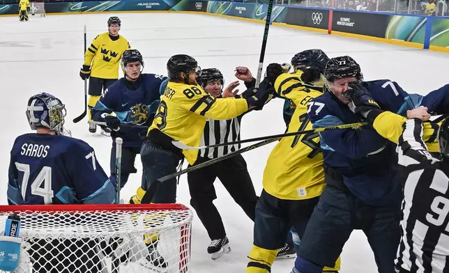 Sweden and Finland players fight, during a preliminary round match of men's ice hockey between Finland and Sweden at the 2026 Winter Olympics, in Milan, Italy, Friday, Feb. 13, 2026. (Alexander Nemenov/Pool Photo via AP)
