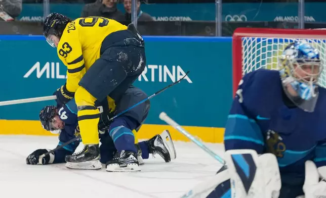 Sweden's Mika Zibanejad, up, challenges Finland's Miro Heiskanen during a preliminary round match of men's ice hockey between Finland and Sweden at the 2026 Winter Olympics, in Milan, Italy, Friday, Feb. 13, 2026. (AP Photo/Hassan Ammar)