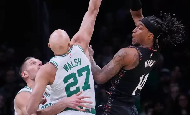 Brooklyn Nets guard Terance Mann, right, passes the ball while pressured by Boston Celtics guard Jordan Walsh (27) during the first half of an NBA basketball game, Friday, Feb. 27, 2026, in Boston. (AP Photo/Charles Krupa)