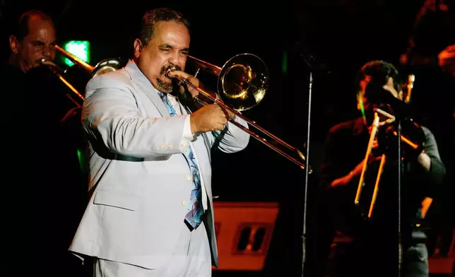 FILE - Willie Colon plays the trombone while performing the song "La Murga" during a tribute concert in honor of the late salsa music pioneer Hector Lavoe in San Juan, Puerto Rico, Sept. 7, 2007. Colón, considered by many to be the "architect of urban salsa," died Saturday, Feb. 21, 2026. He was 75. (AP Photo/Andres Leighton, File)