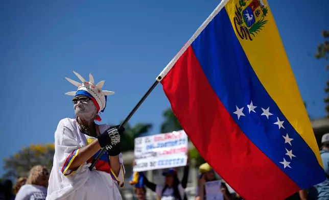 A demonstrator holds a Venezuelan flag during a student-led march calling for the release of people whose relatives and human rights groups consider political prisoners on National Youth Day in Caracas, Venezuela, Thursday, Feb. 12, 2026.(AP Photo/Ariana Cubillos)
