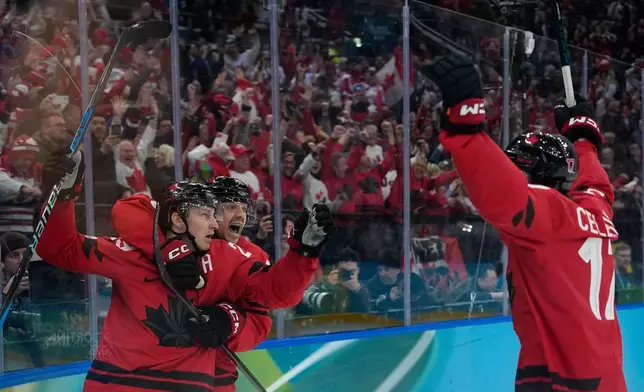 Canada's Nathan MacKinnon (29) celebrates with teammates after scoring his side's third goal during a men's ice hockey semifinal game between Canada and Finland at the 2026 Winter Olympics, in Milan, Italy, Friday, Feb. 20, 2026. (AP Photo/Petr David Josek)