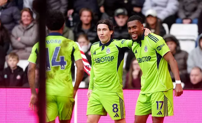 Fulham's Alex Iwobi, right, celebrates with his team mates after scoring his sides third goal during their English Premier League soccer match against Sunderland in Sunderland, England, Sunday, Feb. 22, 2026. (Owen Humphreys/PA via AP)