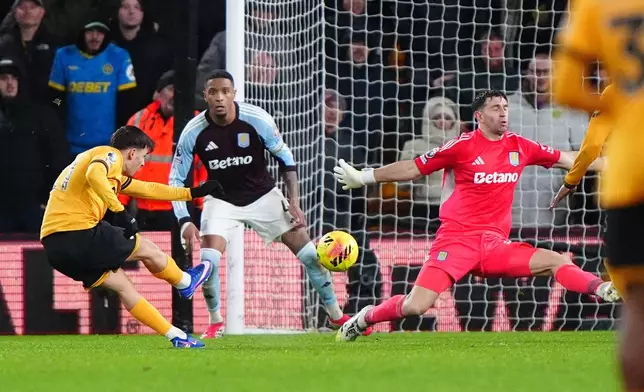 Wolverhampton Wanderers' Rodrigo Gomes, left, scores their second goal during their English Premier League soccer match against Aston Villa in Wolverhampton, England, Friday, Feb. 27, 2026. (Bradley Collyer/PA via AP)