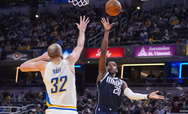 Dallas Mavericks forward Khris Middleton (20) shoots over Indiana Pacers center Jay Huff (32) during the first half of an NBA basketball game in Indianapolis, Sunday, Feb. 22, 2026. (AP Photo/Michael Conroy)
