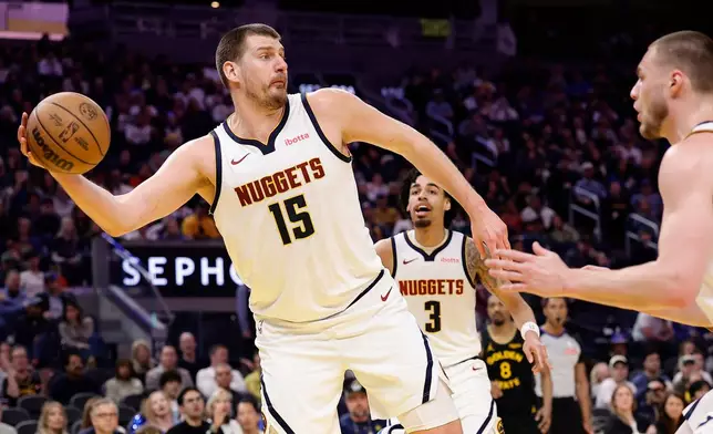 Denver Nuggets center Nikola Jokic keeps the ball in play during the first half of an NBA basketball game against the Golden State Warriors, Sunday, Feb. 22, 2026, in San Francisco. (AP Photo/Kelley L Cox)