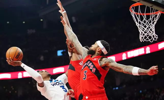 Minnesota Timberwolves' Jaden McDaniels (3) is fouled by Toronto Raptors' Collin Murray-Boyles (centre back) as Brandon Ingram (3) defends during the first half of an NBA basketball game in Toronto, Wednesday, Feb. 4, 2026. (Frank Gunn/The Canadian Press via AP)