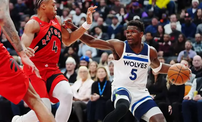 Minnesota Timberwolves' Anthony Edwards (5) protects the ball from Toronto Raptors' Scottie Barnes (4) during the first half of an NBA basketball game in Toronto, Wednesday, Feb. 4, 2026. (Frank Gunn/The Canadian Press via AP)