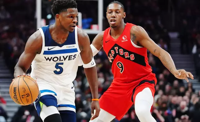 Minnesota Timberwolves' Anthony Edwards (5) protects the ball from Toronto Raptors' RJ Barrett (9) during the first half of an NBA basketball game in Toronto, Wednesday, Feb. 4, 2026. (Frank Gunn/The Canadian Press via AP)