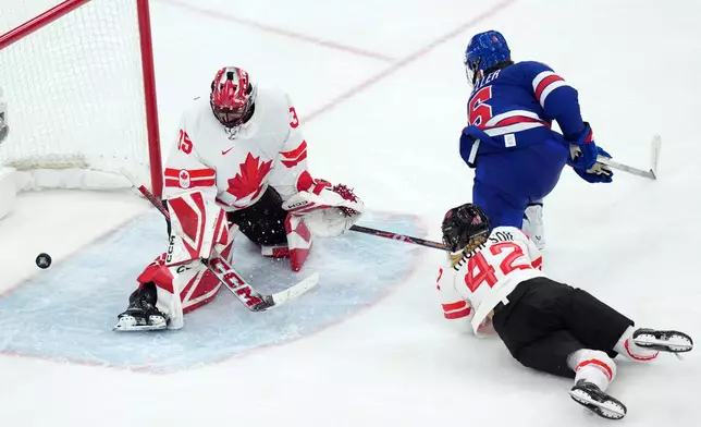 United States' Megan Keller (5) scores the winning goal against Canada goalkeeper Ann-Renee Desbiens (35) during the overtime period of the women's ice hockey gold medal game at the 2026 Winter Olympics, in Milan, Italy, Thursday, Feb. 19, 2026. (AP Photo/Carolyn Kaster)