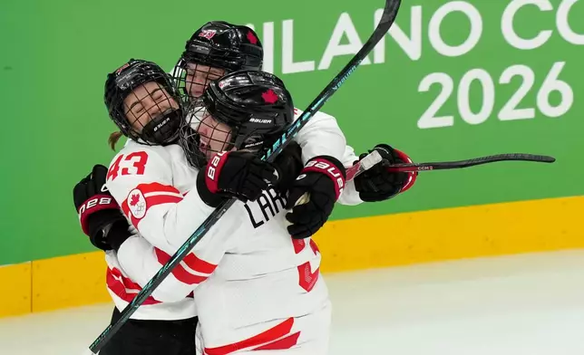 Canada's Kristin O'Neill (43) celebrates with Jocelyne Larocque (3) and Erin Ambrose (23) after O'Neill scored against the United States during the second period of the women's ice hockey gold medal game at the 2026 Winter Olympics, in Milan, Italy, Thursday, Feb. 19, 2026. (AP Photo/Carolyn Kaster)