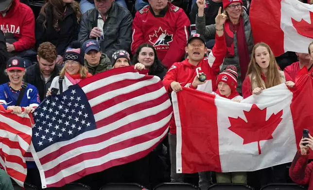 Fans cheer for their teams during the first period of the women's ice hockey gold medal game between the United States and Canada at the 2026 Winter Olympics, in Milan, Italy, Thursday, Feb. 19, 2026. (AP Photo/Carolyn Kaster)