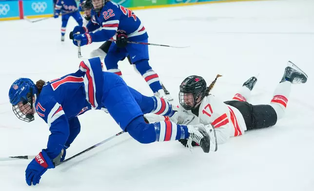 Canada's Ella Shelton (17) trips United States' Britta Curl (17) during a women's ice hockey gold medal game between the United States and Canada at the 2026 Winter Olympics, in Milan, Italy, Thursday, Feb. 19, 2026. (AP Photo/Petr David Josek)
